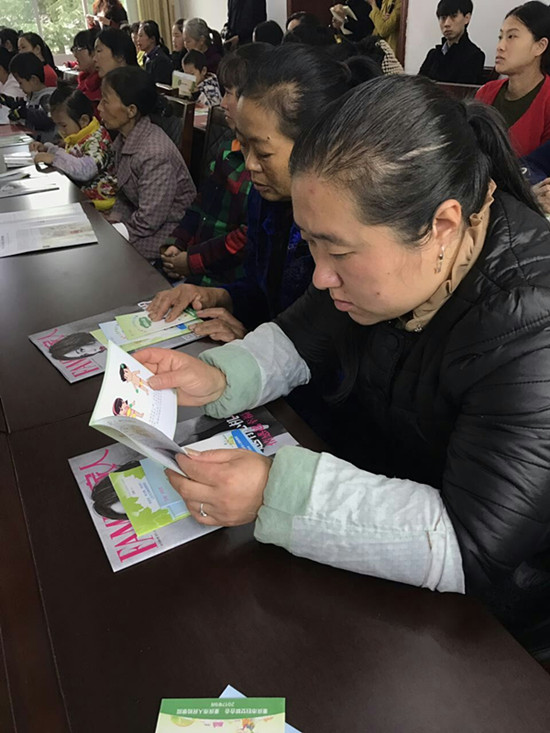 家长认真翻看教育读本.jpg 916462829654495331